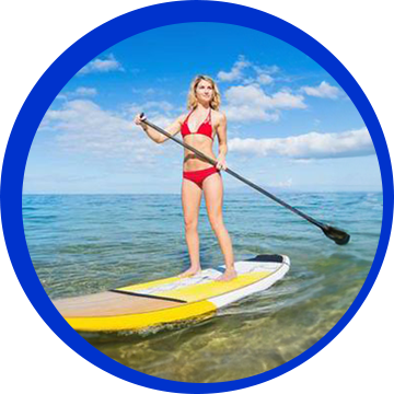 A woman in red bikini standing on a yellow surfboard.