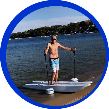 A man standing on the shore of a lake.