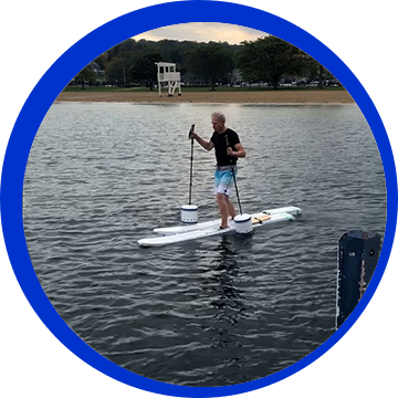 A man is on a paddle board in the water.