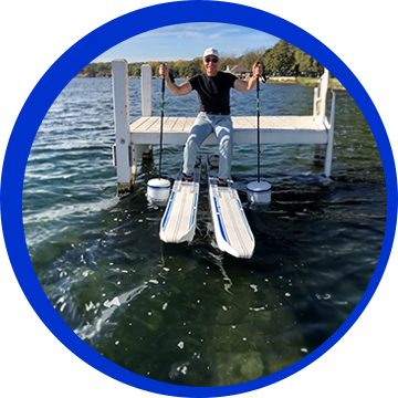 A man riding on the back of a boat in water.